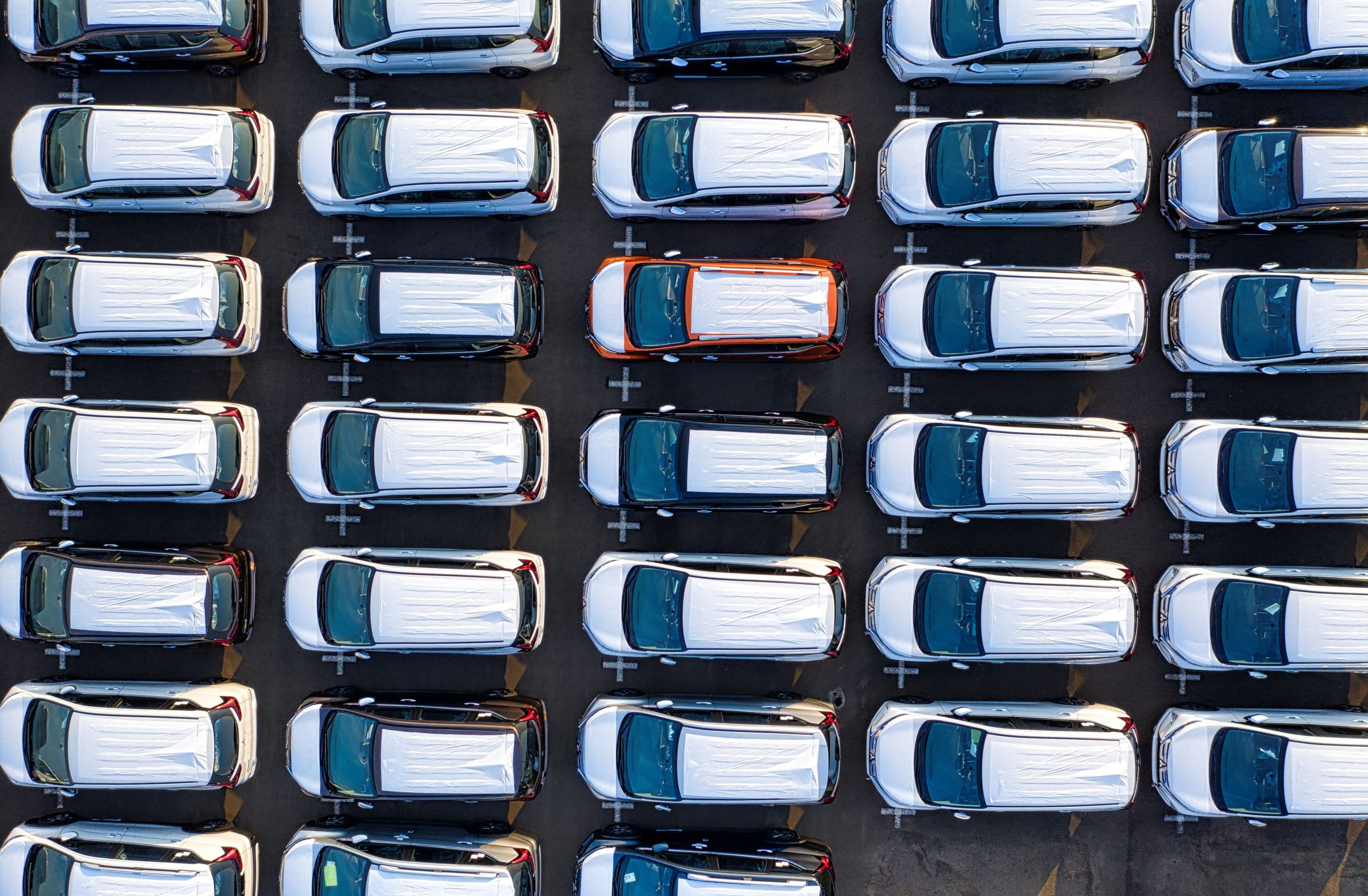 Wagenpark met leaseauto's in rijen op een terrein, van bovenaf gezien