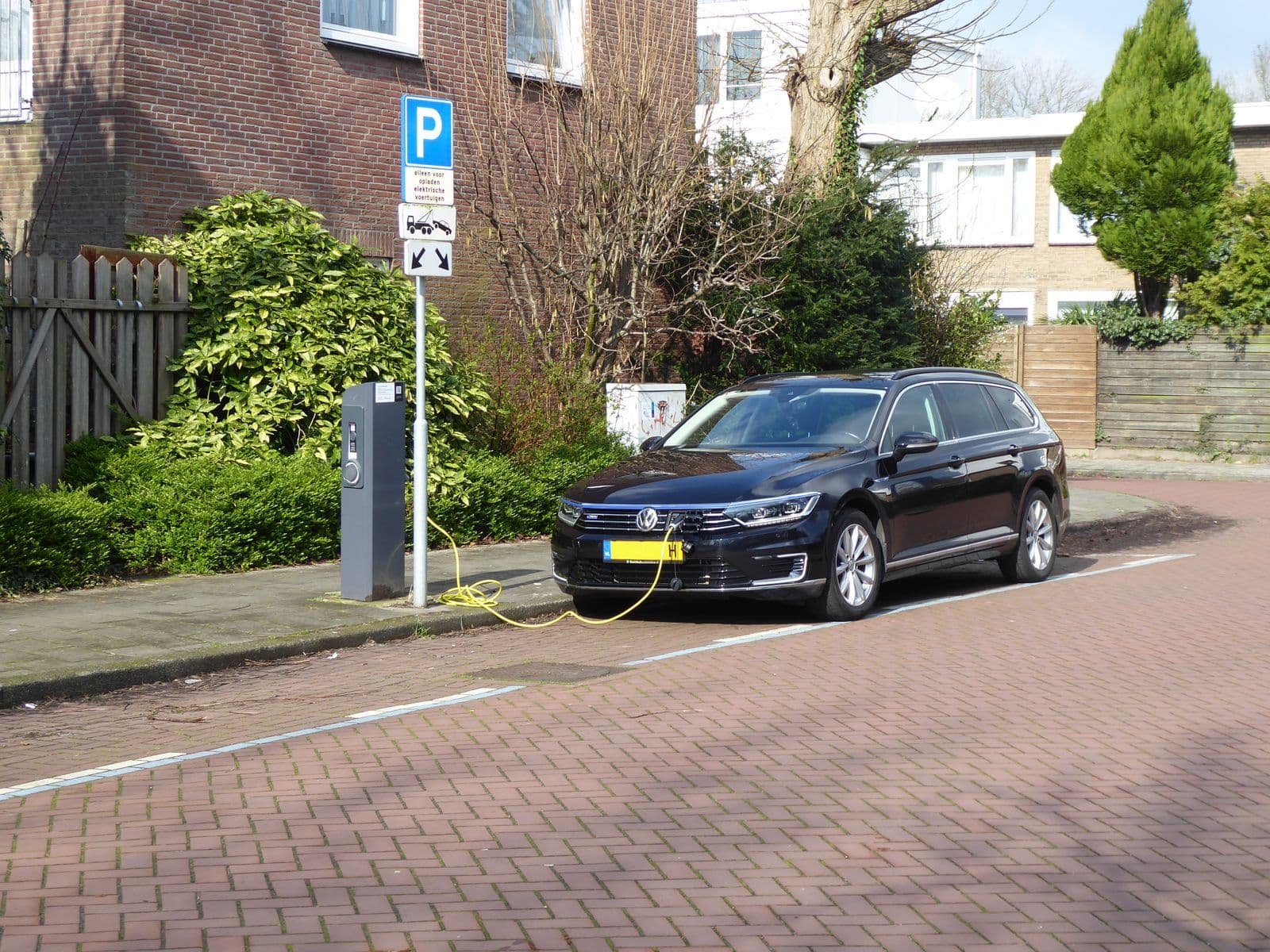 Elektrische auto aan een laadpaal in een woonstraat